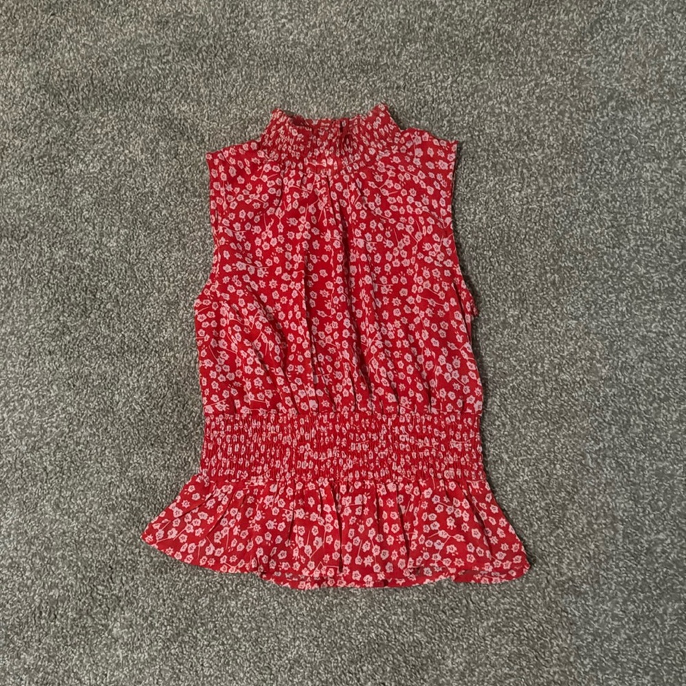 A cute red floral sleeveless blouse.